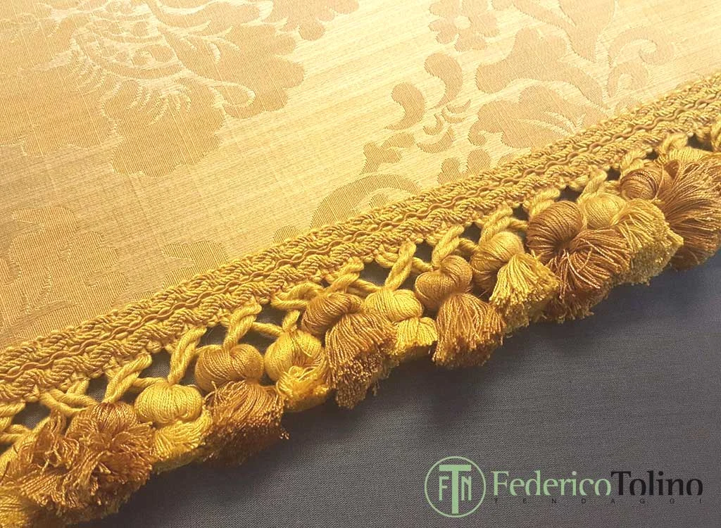 Passamaneria dorata con piccole nappine decorative